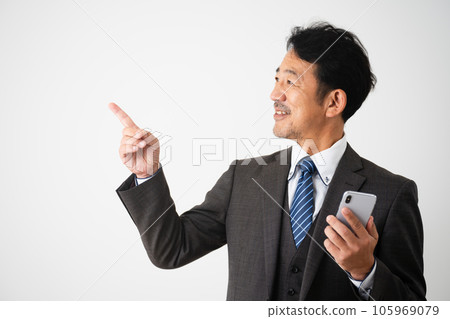 Business image of a middle-aged man holding a smartphone and pointing 105969079