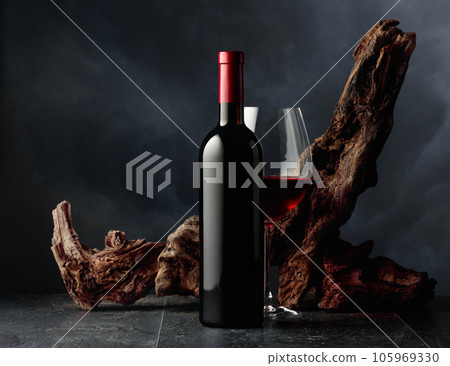 Red wine and old weathered snag on a black stone table. Red wine and old weathered snag on a black stone table. 105969330