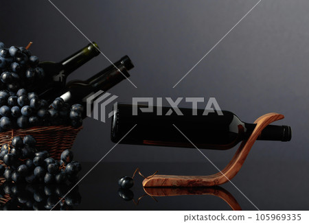 Red wine and blue grapes on a black reflective background. Red wine and blue grapes on a black reflective background. 105969335