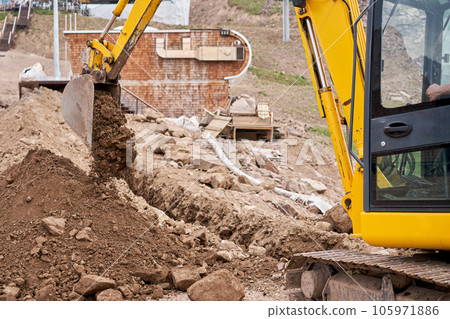 Excavator works in the highlands. Makes a trench for communications. water and electricity. in the gorge of the mountains. repair and expansion of a road 105971886