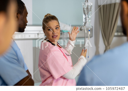 Caucasian female doctor with diverse trainee doctors applying drip at hospital Caucasian female doctor with diverse trainee doctors applying drip at hospital 105972487