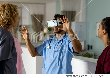 Diverse doctors using vr headset at reception desk at hospital 105972496