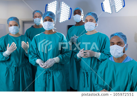 Portrait of diverse surgeons wearing surgical gowns in operating theatre at hospital 105972551