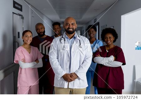 Portrait of happy diverse doctors standing in corridor at hospital 105972724
