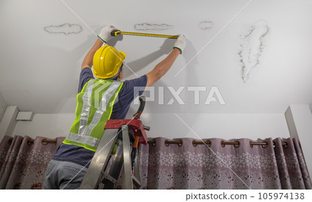 Worker fix leaking pipe in ceiling ,close-up of a stain on the ceiling. 105974138