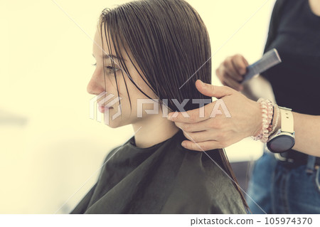 Hairdresser preparing hair of girl for haircut. Female child in beauty salon Hairdresser preparing hair of girl for haircut. Female child in beauty salon 105974370