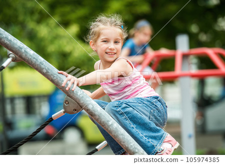 Happy cute little girl playing at the playground outdoor 105974385