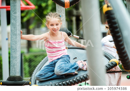 Happy little girl playing at the playground outdoor 105974386
