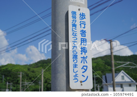 A push-button traffic light sign that says Pedestrian push-button 105974491