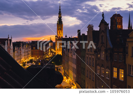 Beautiful old town in Gdansk at summer dusk Poland. Sunset night view from the window rooftop on historical centre Dluga street and city hall architecture buildings St Mary Basilica. Travel attraction Beautiful old town in Gdansk at summer dusk Poland. Sunset night view from the window rooftop on historical centre Dluga street and city hall architecture buildings St Mary Basilica. Travel attraction 105976053