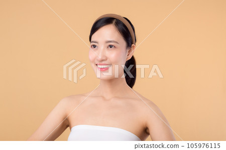 beauty asian young woman model with fresh glowing hydrated facial skin. girl person with natural makeup and healthy skin portrait isolated on beige studio background. spa treatment, skin care concept. 105976115