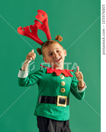 Portrait fo little boy, happy child in costume of elf cheerfully posing against green studio background Portrait fo little boy, happy child in costume of elf cheerfully posing against green studio background 105976805