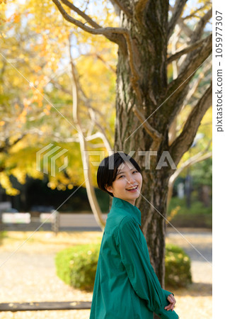 A woman enjoying the autumn leaves A woman enjoying the autumn leaves 105977307