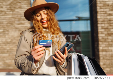 Hands of beautiful woman with telephone, credit card. Online shopping concept, lifestyle concept. 105977445