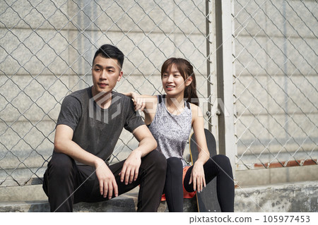 young asian adult man and woman resting relaxing outdoors after exercise young asian adult man and woman resting relaxing outdoors after exercise 105977453