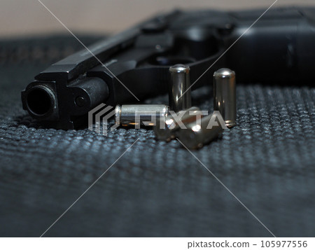 Close-up of a pistol with ammunition. Close-up of a pistol with ammunition. 105977556