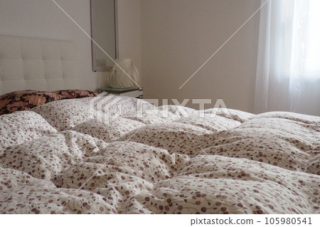 Double bridal bed with pillows and thick feather duvet. Bedroom design. Soft white headboard. Interior with furniture and bedding Double bridal bed with pillows and thick feather duvet. Bedroom design. Soft white headboard. Interior with furniture and bedding 105980541