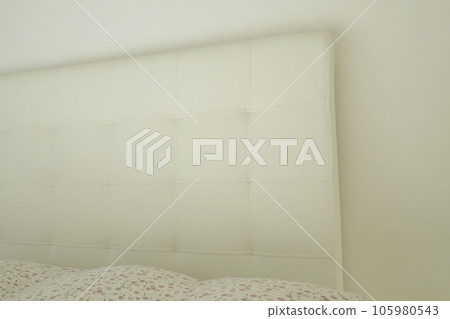 Soft headboard. Upholstery for furniture made of genuine or artificial leather and fabric. Soft headboard against a light wall Soft headboard. Upholstery for furniture made of genuine or artificial leather and fabric. Soft headboard against a light wall 105980543