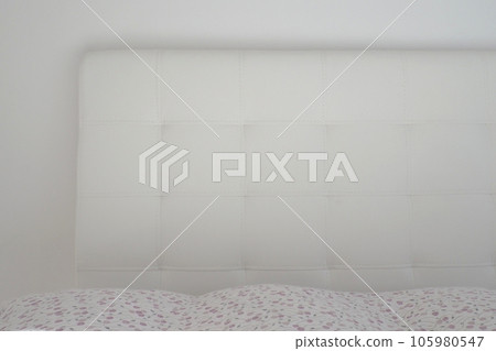 Soft headboard. Upholstery for furniture made of genuine or artificial leather and fabric. Soft headboard against a light wall Soft headboard. Upholstery for furniture made of genuine or artificial leather and fabric. Soft headboard against a light wall 105980547