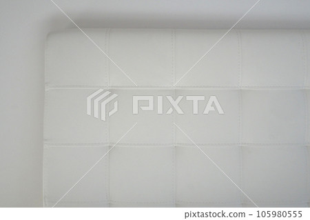 Soft headboard. Upholstery for furniture made of genuine or artificial leather and fabric. Soft headboard against a light wall Soft headboard. Upholstery for furniture made of genuine or artificial leather and fabric. Soft headboard against a light wall 105980555