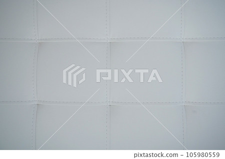 Soft headboard. Upholstery for furniture made of genuine or artificial leather and fabric. Soft headboard against a light wall Soft headboard. Upholstery for furniture made of genuine or artificial leather and fabric. Soft headboard against a light wall 105980559