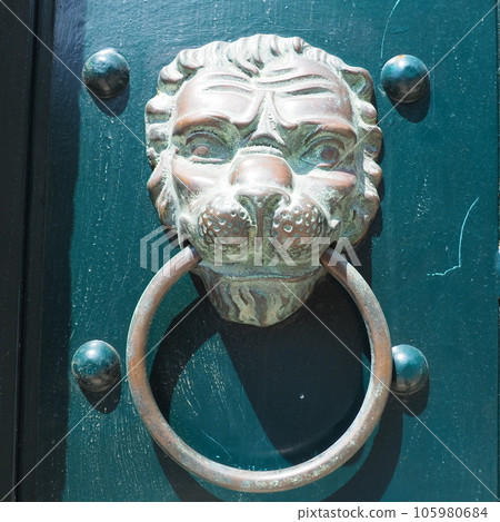 A door knocker is a fixture on the front door of a house. It is made of metal and has the form of a ring, which is knocked on the metal part of the door knocker fixed to the wall. Muzzle of a lion A door knocker is a fixture on the front door of a house. It is made of metal and has the form of a ring, which is knocked on the metal part of the door knocker fixed to the wall. Muzzle of a lion 105980684