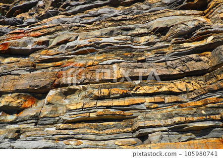Flysch is a series of marine sedimentary rocks that are predominantly clastic in origin and are characterized by the alternation of lithological layers. Balkans, Montenegro, Budva, Mogren beach. 105980741