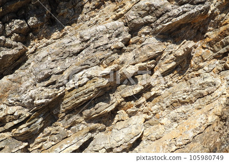 Flysch is a series of marine sedimentary rocks that are predominantly clastic in origin and are characterized by the alternation of lithological layers. Balkans, Montenegro, Budva, Mogren beach. 105980749