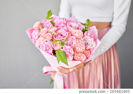 Beautiful large bouquet of mixed flowers in decor wrap. Handsome fresh bouquet in woman hand. Small flower shop and Flowers delivery. Beautiful large bouquet of mixed flowers in decor wrap. Handsome fresh bouquet in woman hand. Small flower shop and Flowers delivery. 105981805