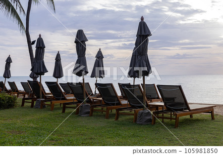 back view of beach chairs and umbrella with sunset on tropical vacation at sea in thailand back view of beach chairs and umbrella with sunset on tropical vacation at sea in thailand 105981850