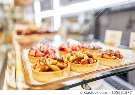 Honey cake with strawberries. fresh pastries with berries. A variety of fresh pastries in the bakery window. Strawberry cake. The interior of an Italian restaurant. 105981877