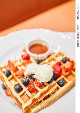Classic Viennese waffles with ice cream, berries and Maple syrup. Breakfast in cafe. Table in the restaurant. 105981889
