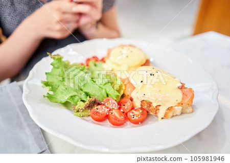Brioche, poached egg, avocado cream with salmon and egg . Healthy breakfast, protein. Restaurant dish. Brioche, poached egg, avocado cream with salmon and egg . Healthy breakfast, protein. Restaurant dish. 105981946