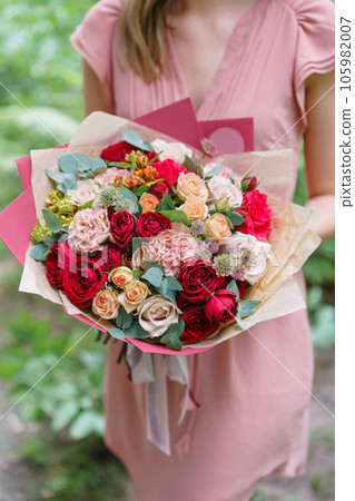Beautiful bouquet with garden roses flowers in woman hand. Floral shop concept . Beautiful fresh cut bouquet. Flowers delivery 105982007