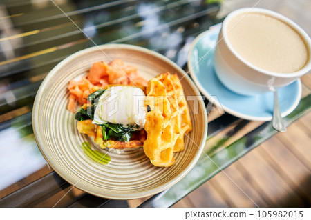 Potato waffles, Poached egg, avocado cream with salmon and egg . Healthy breakfast, protein. Restaurant dish.  105982015