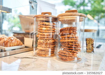 Oatmeal cookies on the marble kitchen table. Transparent glass jars with cookies in the interior of the cafe. Stylish interior of the kitchen of a trendy restaurant. decorative elements. Oatmeal cookies on the marble kitchen table. Transparent glass jars with cookies in the interior of the cafe. Stylish interior of the kitchen of a trendy restaurant. decorative elements. 105982027