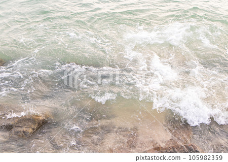Water splashes from wave bumping against rocky shore brown. which is important tourist destination. Background image is sea blue of bright sunlight make picture very bright. Beach at Penang Malaysia. Water splashes from wave bumping against rocky shore brown. which is important tourist destination. Background image is sea blue of bright sunlight make picture very bright. Beach at Penang Malaysia. 105982359