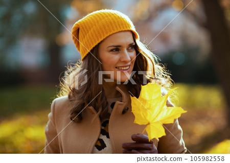 happy trendy woman in beige coat and orange hat happy trendy woman in beige coat and orange hat 105982558