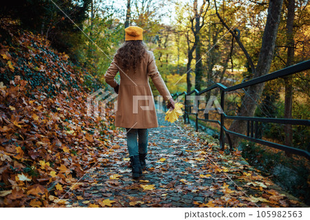 Seen from behind woman in brown coat and hat enjoying promenade Seen from behind woman in brown coat and hat enjoying promenade 105982563