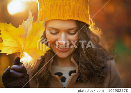 smiling woman in beige coat and orange hat smiling woman in beige coat and orange hat 105982578