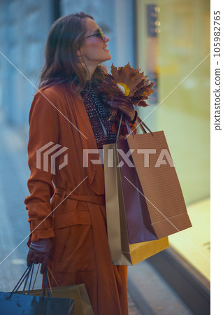 smiling stylish 40 years old woman in brown trench coat 105982765