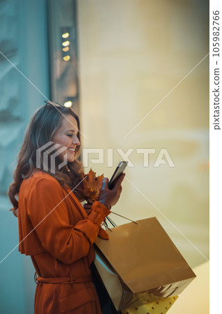smiling trendy woman in brown trench coat smiling trendy woman in brown trench coat 105982766