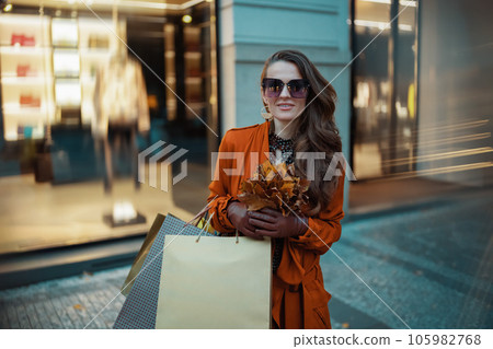 smiling young 40 years old woman in orange trench coat smiling young 40 years old woman in orange trench coat 105982768