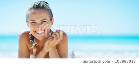 smiling young woman laying on beach 105983012