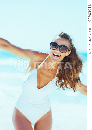 Happy young woman in swimsuit having fun time on beach Happy young woman in swimsuit having fun time on beach 105983018