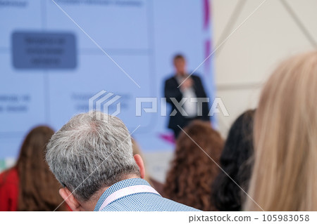 Unrecognizable man listening to presentation of speaker Unrecognizable man listening to presentation of speaker 105983058