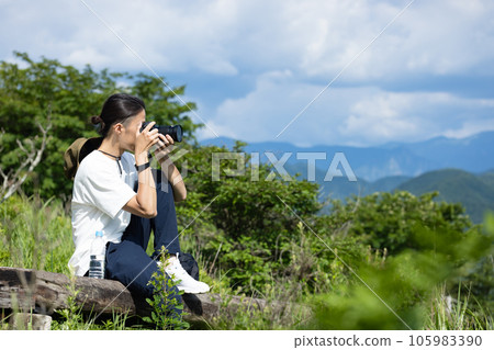 man holding a camera in the mountains 105983390