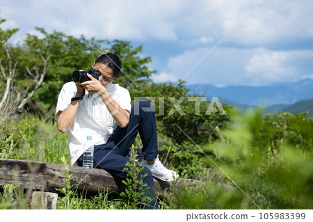 man holding a camera in the mountains 105983399