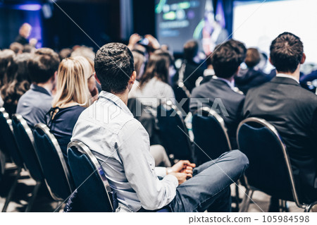 Speaker giving a talk in conference hall at business event. Rear view of unrecognizable people in audience at the conference hall. Business and entrepreneurship concept Speaker giving a talk in conference hall at business event. Rear view of unrecognizable people in audience at the conference hall. Business and entrepreneurship concept 105984598