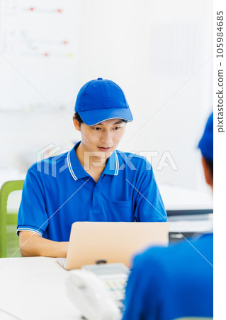 A driver wearing work clothes doing desk work in the office A driver wearing work clothes doing desk work in the office 105984685